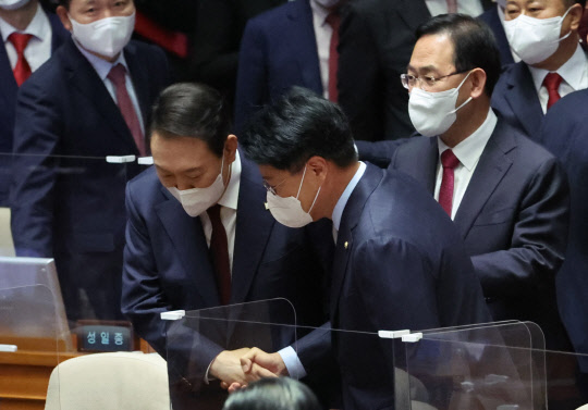 윤석열 대통령이 25일 오전 국회 본회의장에서 시정연설을 마친 뒤 국민의힘 장제원 의원과 악수하며 귀엣말을 하고 있다.연합뉴스
